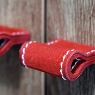 Unique cabinet hardware made of red leather with white seams Unique cabinet hardware made of red leather with white seams