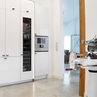 Kitchen handles made of leather and aluminium at a white kitchen Kitchen handles made of leather and aluminium at a white kitchen