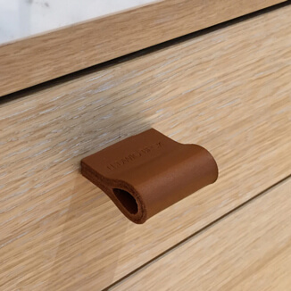 Leather loop in orange brown on dresser Leather loops in orange brown on dresser