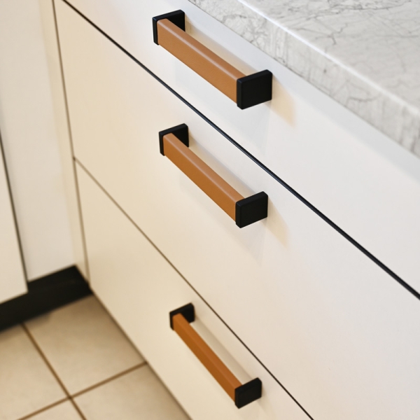 Appliance pull ROMA in color BEIGE BROWN with Black mounting plates at a white kitchen