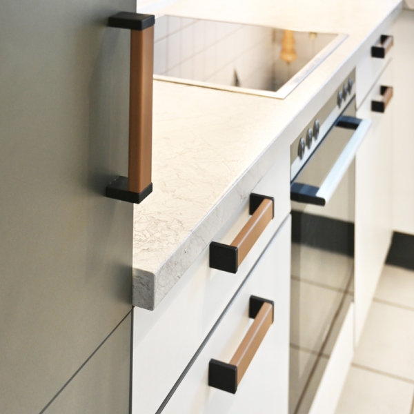 Kitchen handles ROMA  in color BEIGE BROWN with Black mounting plates at a white kitchen